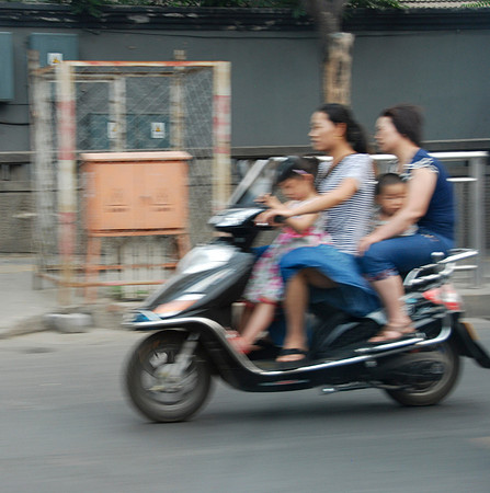 Four people on this motorcycle.  Note no helmets even for the young children.