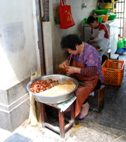 She was making these rice things rolled up in long leaves.