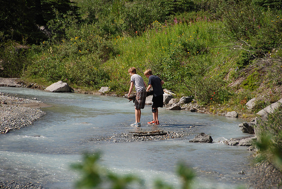 The boys spent a long time building a bridge of logs so they could cross and stay dry.  Their shoes got soaked in the process!