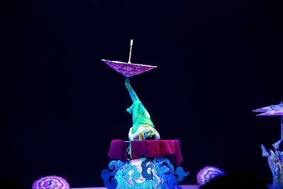 Spinning and juggling umbrellas on her feet.